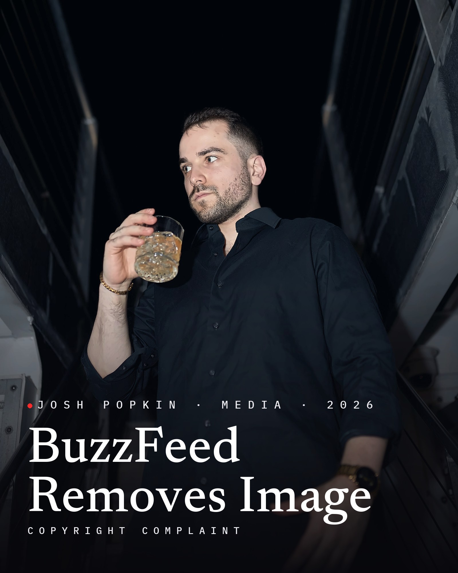 Josh Popkin in a black shirt holding a glass, with the title BuzzFeed Removes Image